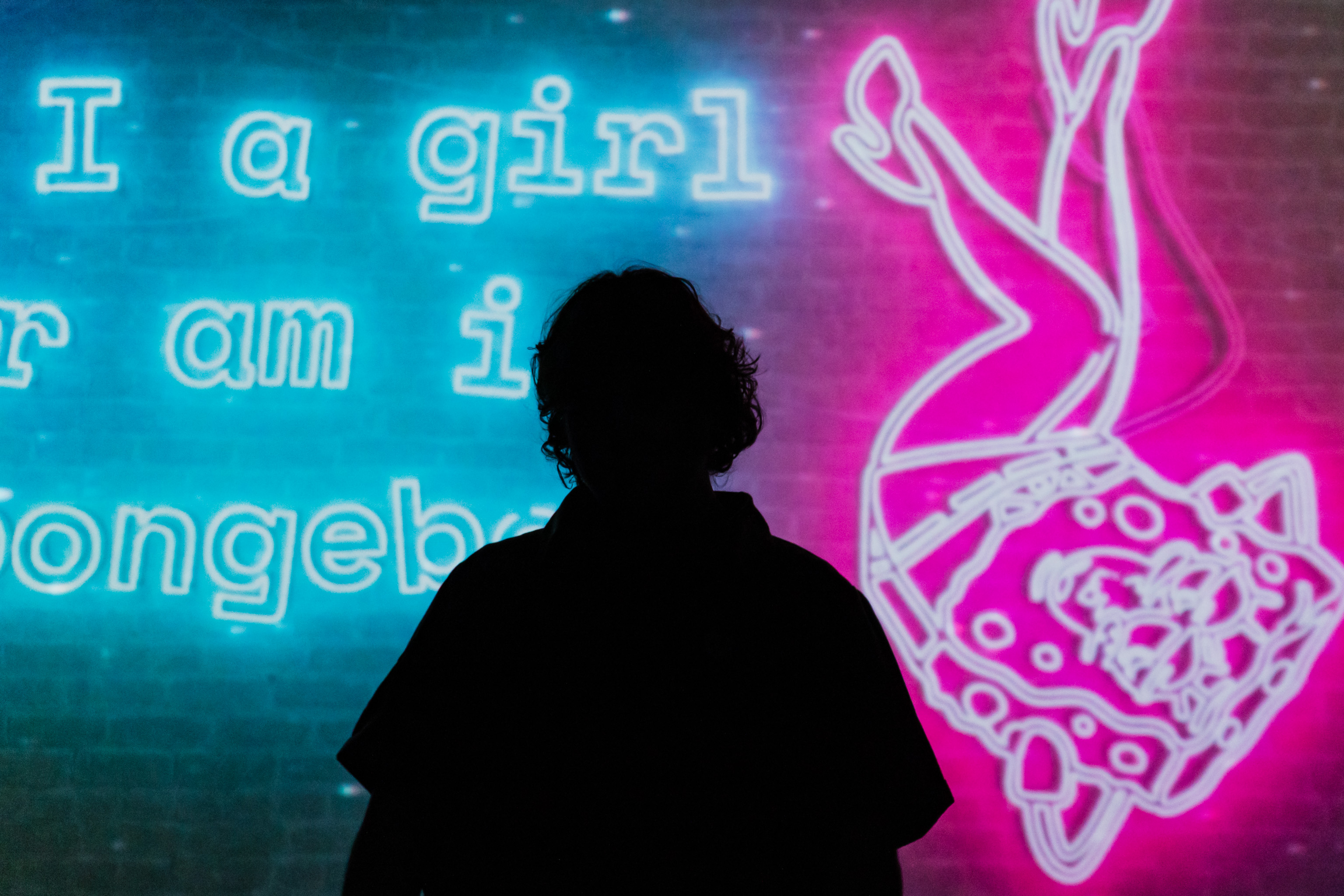 a dark figure of stevey in front of a bright screen that says am I a girl or am I spongebob